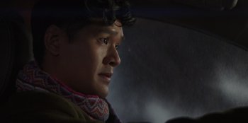 Movie still from “I Believe in Santa” (2022), directed by Alex Ranarivelo – A man in a car looking out the window at night; Close Up shot, Over the shoulder angle