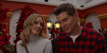 Movie still from “I Believe in Santa” (2022), directed by Alex Ranarivelo – A man and a woman standing next to each other in front of christmas lights; Close Up shot, Over the shoulder angle