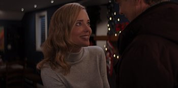 Movie still from “I Believe in Santa” (2022), directed by Alex Ranarivelo – A woman smiles at the camera as a man looks on; Close Up shot, Over the shoulder angle