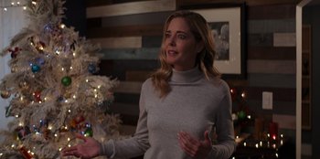 Movie still from “I Believe in Santa” (2022), directed by Alex Ranarivelo – A woman standing in front of a christmas tree; Medium shot, Over the shoulder angle