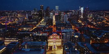 Movie still from “I Believe in Santa” (2022), directed by Alex Ranarivelo – An aerial view of a large city at night; Extreme Wide shot, High angle