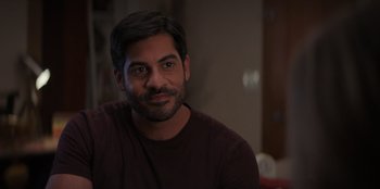 Movie still from “I Believe in Santa” (2022), directed by Alex Ranarivelo – A person sitting in a room; Close Up shot, Over the shoulder angle