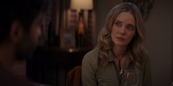 Movie still from “I Believe in Santa” (2022), directed by Alex Ranarivelo – A woman sitting at a table with a glass of wine; Close Up shot, Over the shoulder angle