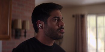 Movie still from “I Believe in Santa” (2022), directed by Alex Ranarivelo – A person wearing a ear piece; Close Up shot, Over the shoulder angle