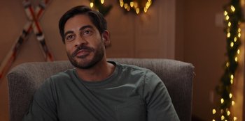 Movie still from “I Believe in Santa” (2022), directed by Alex Ranarivelo – A person sitting on a couch; Close Up shot, Over the shoulder angle