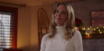Movie still from “I Believe in Santa” (2022), directed by Alex Ranarivelo – A woman in a white shirt is standing in a room; Close Up shot, Over the shoulder angle