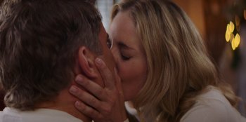 Movie still from “I Believe in Santa” (2022), directed by Alex Ranarivelo – A man and a woman kissing each other in front of a window; Close Up shot, Low angle