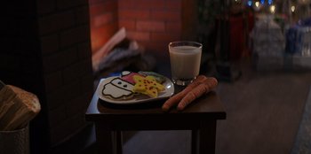 Movie still from “I Believe in Santa” (2022), directed by Alex Ranarivelo – A plate of food and a glass of milk on a table; Extreme Close Up shot, High angle