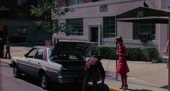 Movie still from “I Spit on Your Grave” (1978), directed by Meir Zarchi – A man and a woman unloading a trunk from a parked car; Wide shot, High angle