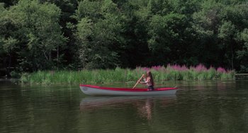 Movie still from “I Spit on Your Grave” (1978), directed by Meir Zarchi – A woman is rowing a boat on a lake; Extreme Wide shot, High angle