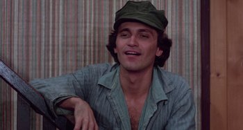 Movie still from “I Spit on Your Grave” (1978), directed by Meir Zarchi – A man wearing a green hat and a blue shirt; Close Up shot, Low angle