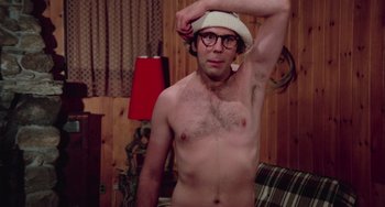 Movie still from “I Spit on Your Grave” (1978), directed by Meir Zarchi – A shirtless man with a hat on his head; Medium shot, Low angle