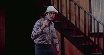 Movie still from “I Spit on Your Grave” (1978), directed by Meir Zarchi – A man wearing a white hat and a plaid shirt; Medium shot, Low angle