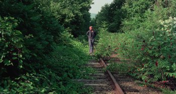 Movie still from “I Spit on Your Grave” (1978), directed by Meir Zarchi – A man standing on a train track in the middle of a forest; Wide shot, High angle