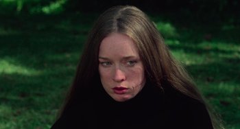 Movie still from “I Spit on Your Grave” (1978), directed by Meir Zarchi – A woman with long brown hair wearing a black sweater; Close Up shot, High angle