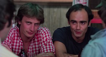 Movie still from “I Spit on Your Grave” (1978), directed by Meir Zarchi – Two men sitting next to each other at a table; Close Up shot, Low angle