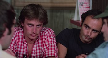 Movie still from “I Spit on Your Grave” (1978), directed by Meir Zarchi – Two young men sitting next to each other in a room; Close Up shot, Over the shoulder angle