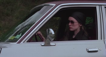 Movie still from “I Spit on Your Grave” (1978), directed by Meir Zarchi – A woman sitting in the driver's seat of a car; Medium shot, Low angle