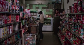 Movie still from “I Spit on Your Grave” (1978), directed by Meir Zarchi – A man is standing in a grocery store looking at items on the counter; Wide shot, Over the shoulder angle