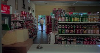 Movie still from “I Spit on Your Grave” (1978), directed by Meir Zarchi – A person walking through a store filled with lots of items; Wide shot, High angle