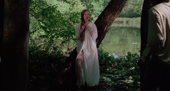 Movie still from “I Spit on Your Grave” (1978), directed by Meir Zarchi – A woman in a long white dress standing next to a tree; Wide shot, High angle