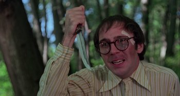 Movie still from “I Spit on Your Grave” (1978), directed by Meir Zarchi – A man holding a knife in his hand and wearing glasses; Close Up shot, Low angle