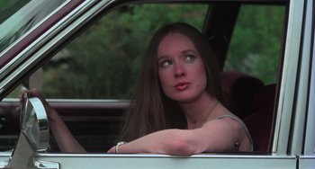 Movie still from “I Spit on Your Grave” (1978), directed by Meir Zarchi – A woman sitting in the driver's seat of a car; Close Up shot, Low angle