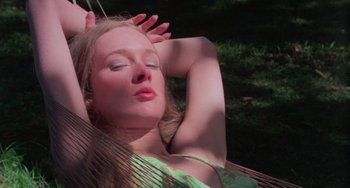 Movie still from “I Spit on Your Grave” (1978), directed by Meir Zarchi – A woman laying in a hammock with her eyes closed; Close Up shot, High angle