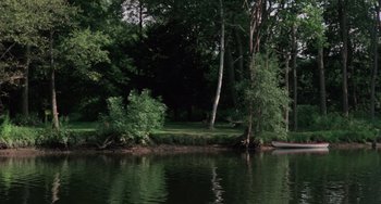 Movie still from “I Spit on Your Grave” (1978), directed by Meir Zarchi – A body of water surrounded by trees and a forest; Extreme Wide shot, High angle