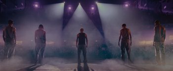 Two men standing on a stage in front of a crowd of people