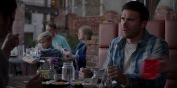 Movie still from “I Want You Back” (2022), directed by Jason Orley – A group of people sitting at a table with food; Medium shot, Over the shoulder angle
