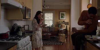 Movie still from “I Want You Back” (2022), directed by Jason Orley – A woman eating a sandwich in a kitchen; Wide shot, Over the shoulder angle
