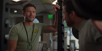 Movie still from “I Want You Back” (2022), directed by Jason Orley – A man is talking to another man at the gym; Close Up shot, Over the shoulder angle