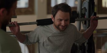 Movie still from “I Want You Back” (2022), directed by Jason Orley – A person holding a barbell on their shoulder; Close Up shot, Over the shoulder angle