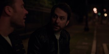 Movie still from “I Want You Back” (2022), directed by Jason Orley – A man in a leather jacket looking at the camera; Close Up shot, Over the shoulder angle