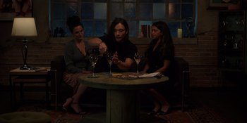Movie still from “I Want You Back” (2022), directed by Jason Orley – A man sitting at a table with two women; Medium shot, High angle