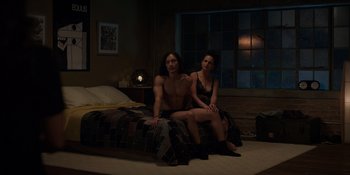 Movie still from “I Want You Back” (2022), directed by Jason Orley – A man and a woman sitting on a bed in front of a window; Wide shot, High angle