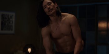 Movie still from “I Want You Back” (2022), directed by Jason Orley – A man with long black hair is posing for the camera; Medium shot, High angle