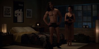 Movie still from “I Want You Back” (2022), directed by Jason Orley – A man and a woman standing next to each other in a bedroom; Wide shot, Low angle