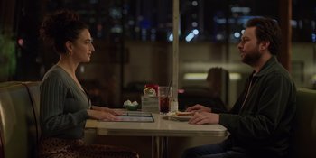 Movie still from “I Want You Back” (2022), directed by Jason Orley – A man and a woman sitting at a table in front of each other; Medium shot, Over the shoulder angle