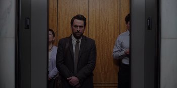 Movie still from “I Want You Back” (2022), directed by Jason Orley – A man in a suit standing in front of two other men; Medium shot, Low angle