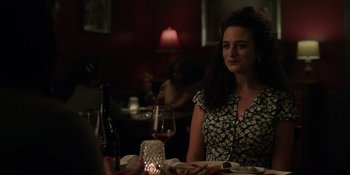 Movie still from “I Want You Back” (2022), directed by Jason Orley – A woman sitting at a table with a glass of red wine; Medium shot, Over the shoulder angle