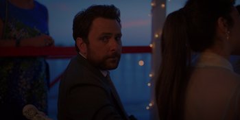 Movie still from “I Want You Back” (2022), directed by Jason Orley – A person wearing a suit and tie; Close Up shot, Over the shoulder angle