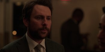 Movie still from “I Want You Back” (2022), directed by Jason Orley – A person wearing a suit and tie; Close Up shot, Over the shoulder angle