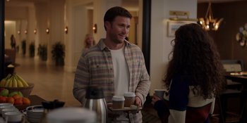 Movie still from “I Want You Back” (2022), directed by Jason Orley – A man holding a tray with two cups of coffee on top of it; Medium shot, Over the shoulder angle