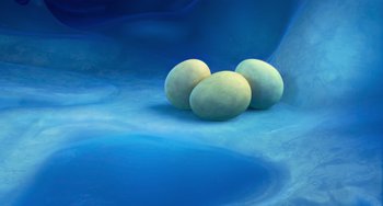 Movie still from “Ice Age: Dawn of the Dinosaurs” (2009), directed by Michael Thurmeier – Three eggs sitting on top of a blue surface; Wide shot, Overhead angle