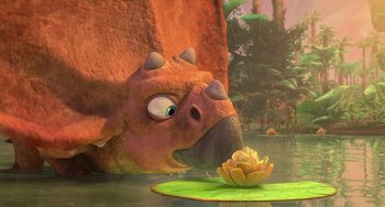 Movie still from “Ice Age: Dawn of the Dinosaurs” (2009), directed by Michael Thurmeier – An image of an animated dinosaur looking at a flower in a pond; Wide shot, High angle