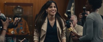 Movie still from “If You Were the Last” (2023), directed by Kristian Mercado – A woman with long brown hair smiles for the camera; Medium shot, Over the shoulder angle