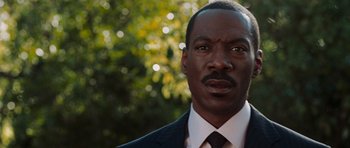 Movie still from “Imagine That” (2009), directed by Karey Kirkpatrick – A person wearing a suit and tie; Close Up shot, Low angle