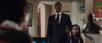 Movie still from “Imagine That” (2009), directed by Karey Kirkpatrick – A man wearing a suit and tie holding a bag; Medium shot, Over the shoulder angle